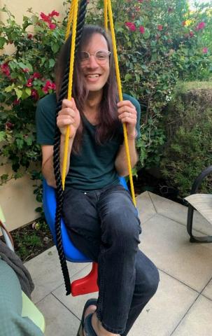 Assistant Professor Mike Schneider sitting in swing